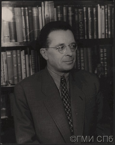 В.Н. Орлов на фоне книг.  1960-е годы
