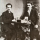 А. Белый и С. М. Соловьев. На столе портреты В. С. Соловьева и Л. Д. Блок. 1904 год.